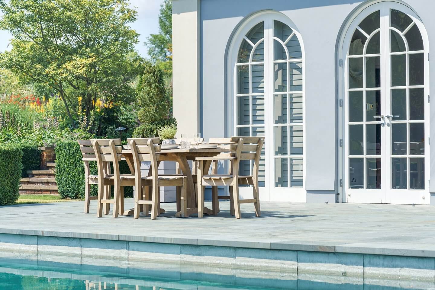 poolside dining with wooden table and chairs