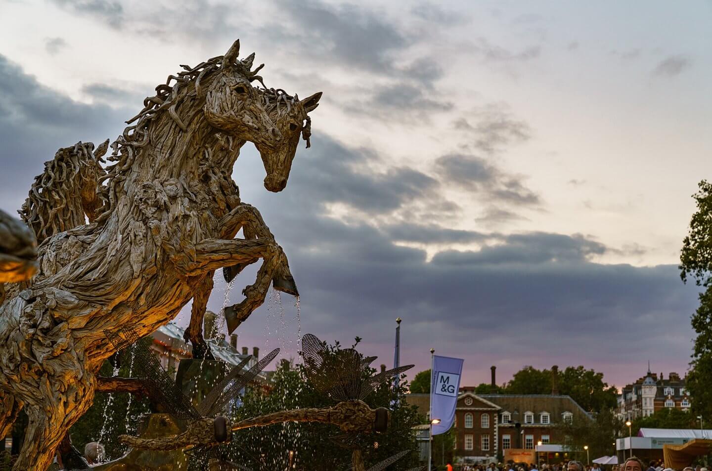 evening falls on autumn Chelsea Flower Show with timber horse sculpture