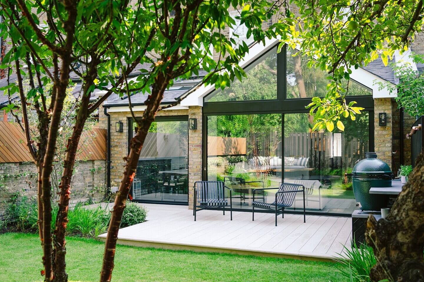 garden design with patio area and seating viewed through trees