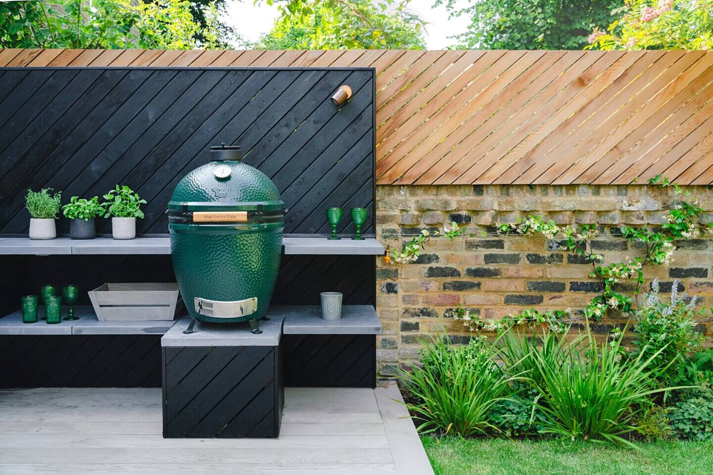 Charred timber and angled timber screening with an outdoor kitchen and Big Green Egg oven for family garden design London