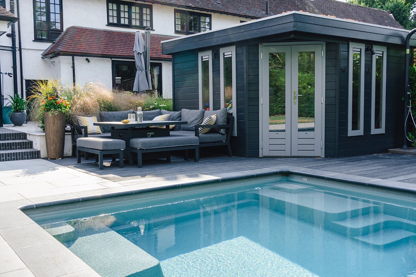 Pool house and seating area with outdoor shower and mixed paving plus decking - family garden design by Helen Rose Wilson